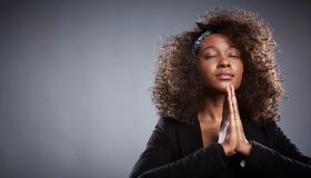 Studio portrait of young businesswoman praying