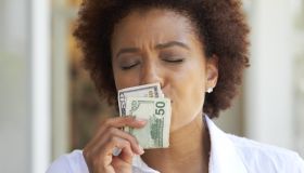 African American woman kissing 50 dollar bill