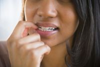 Mixed race woman biting her nail