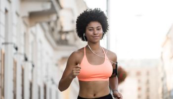 Young woman jogger running with headphones