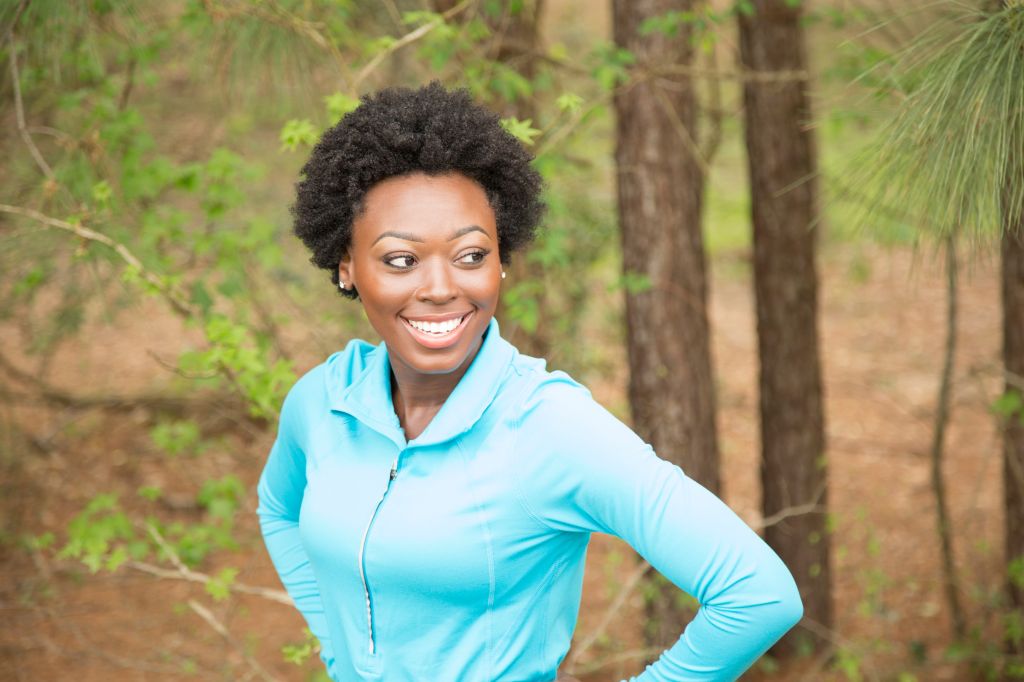 One African descent woman takes break from running in neighborhood park.