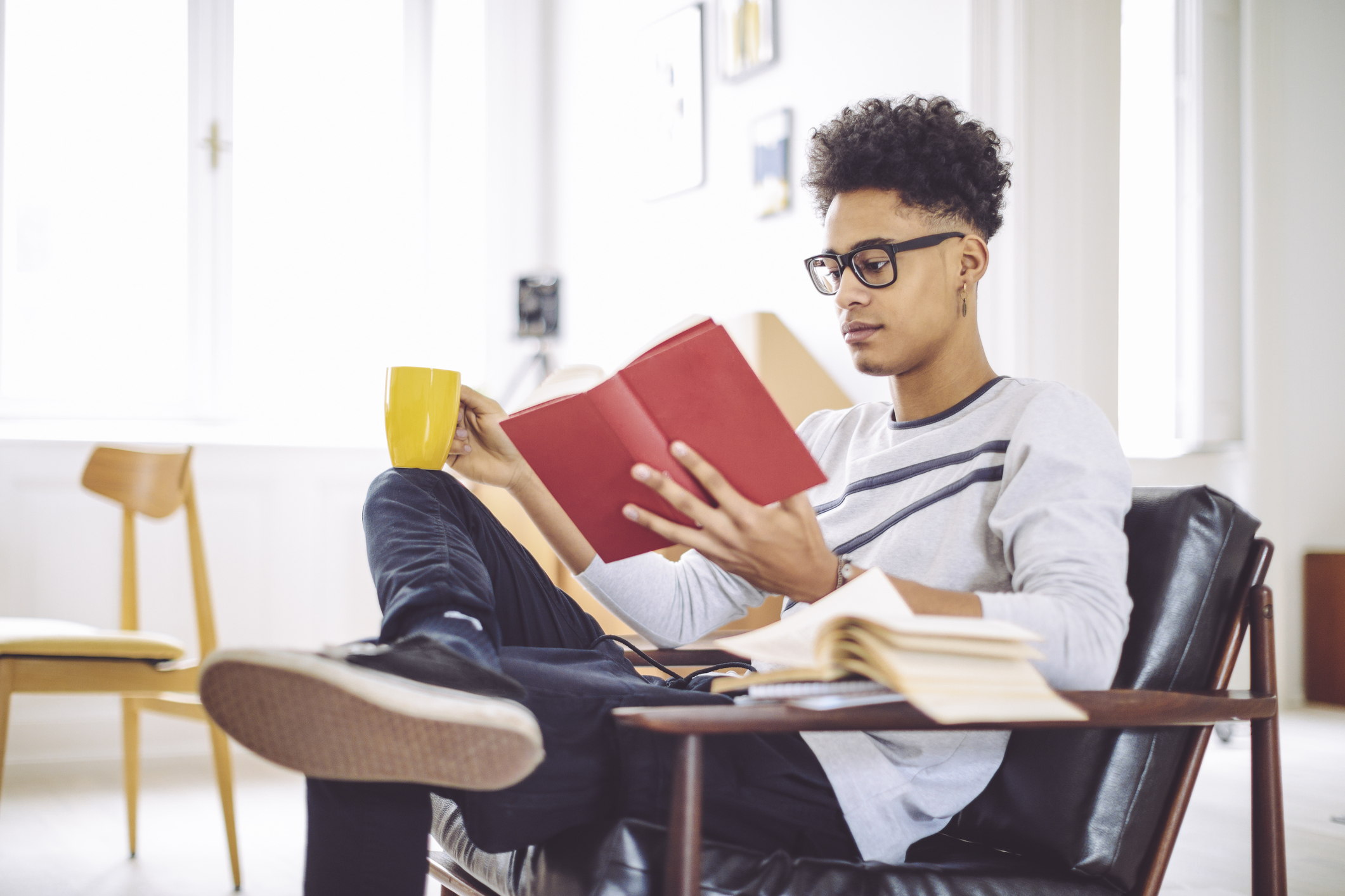 Young man reading a book at home