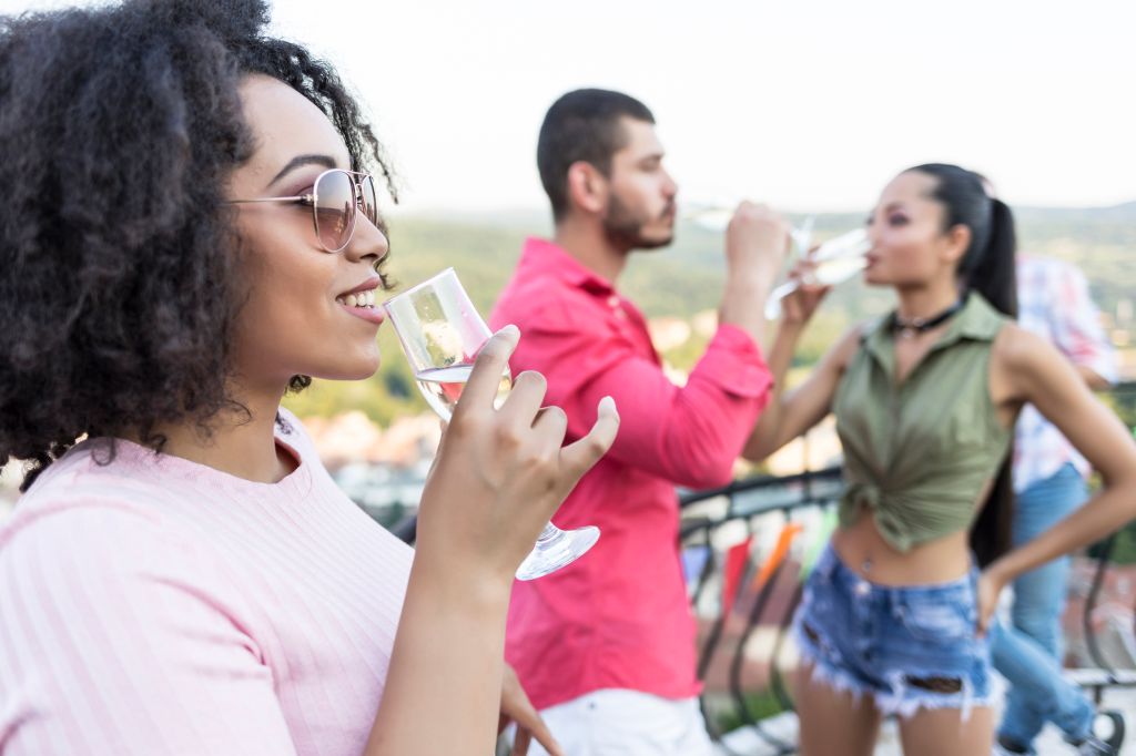 Woman drinking champagne at roof party