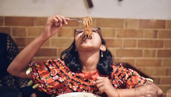 Tweenage girl eating noodles