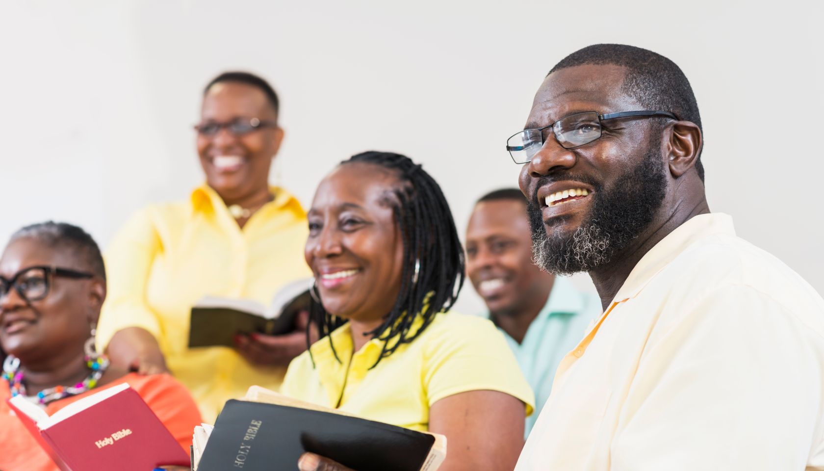 Group of mature black men and women holding bibles