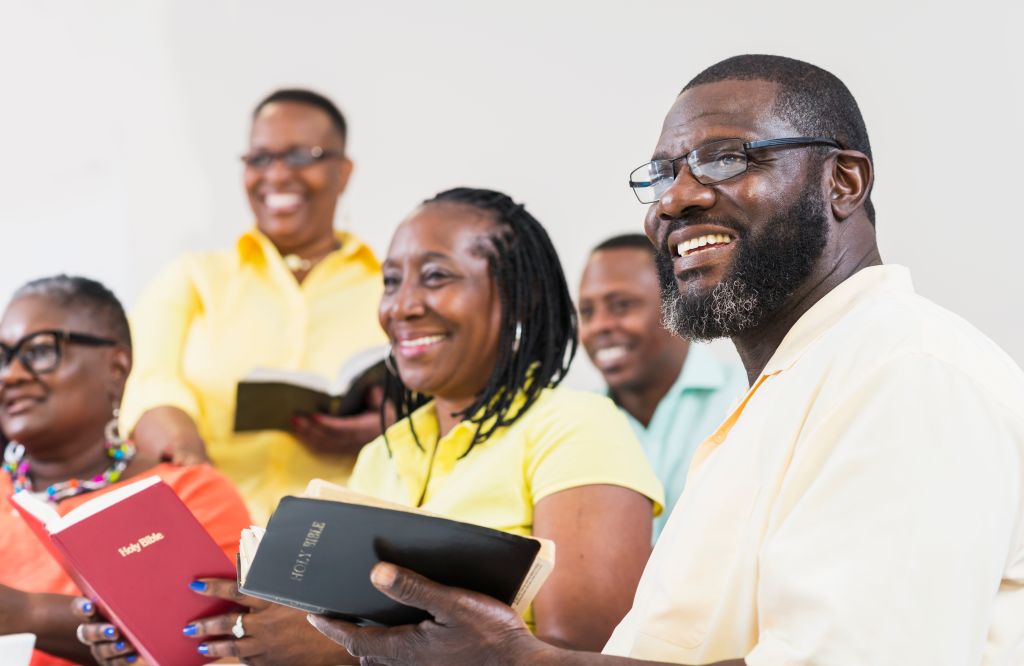 Group of mature black men and women holding bibles