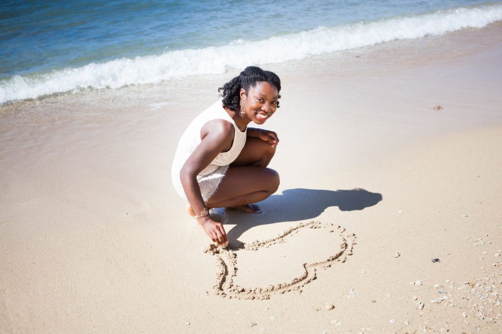 Woman smiling & drawing on sand