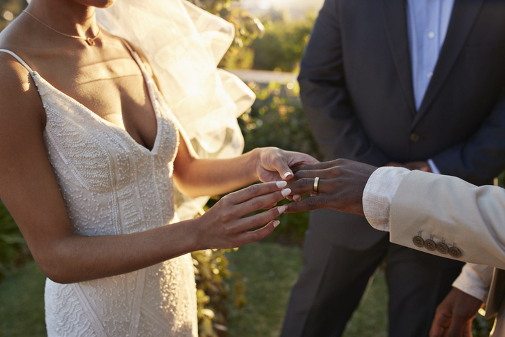 Young bride exchanging wedding ring with groom