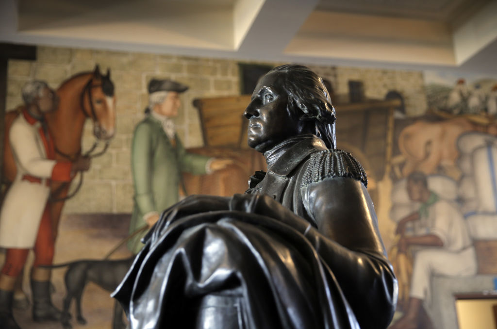 A bronze statue of George Washington is surrounded by murals of the first president's life, including his slave ownership, at George Washington High School in San Francisco, Calif., on Tuesday, September 6, 2016. San Francisco School Board President Matt