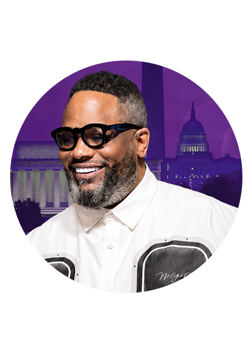 A smiling man wearing sunglasses and a white shirt with "Mr. Eazi" printed on it, standing in front of the U.S. Capitol building.