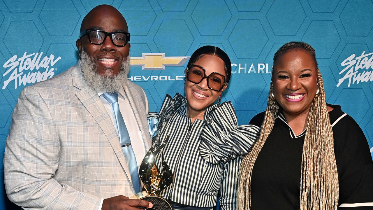 Three smiling people posing in front of a Chevrolet backdrop at the Stellar Awards event.